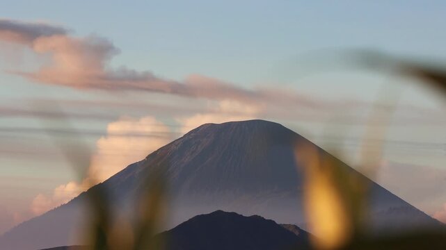 Wide shot of Sunrise Eruption of Mount Semeru Framed by Foreground Silhouettes from King Kong Hill in East Java , Indonesia