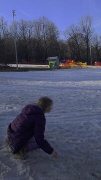 High frame rate vertical 9:16 shot of a girl throwing a snowball at Normafa. Natural color grade and sharp winter textures in a 2026 style.