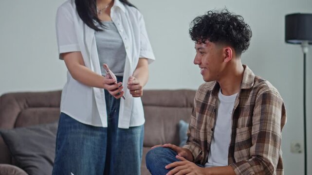Young husband pleading and apologizing to angry wife after takes phone