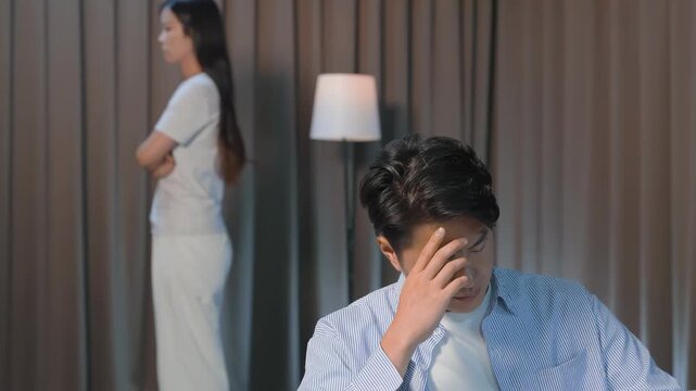 Amid a relationship crisis problems, arguing, insulting, back to back in pain, giving each other the silent treatment, looking dejected angry in dark light, domestic violence abused in family conflict