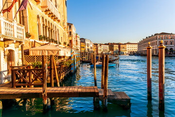 romantic view of a canal in Venice with boats and blue water and beautiful vintage buildings around the cityscape © Yaroslav