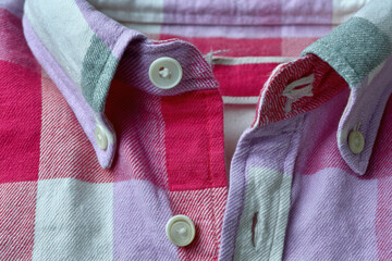 Pink and purple flannel shirt collar with button down detail, close up showing checker pattern and fabric texture