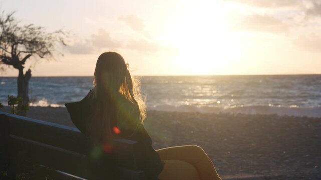 Person relaxing at sunset scene with waves and horizon in Patras Greece