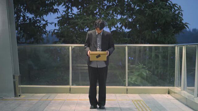 Sad, overwhelmed, depressed unemployed man, businessman fired, unemployed cardboard box, leaves of workplace office. Workforce reduction, downsizing, reorganization, restructuring, outsourcing.