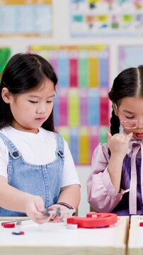 Asian schoolchildren conducting hands-on magnet science experiment together