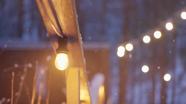 Cozy Winter Scene. Charming Winter Tableau Featuring Glowing Filaments And Delicate Snowfall. Warm And Cozy Winter Setting With Gentle Snow And Luminous Lights Creating Magical Atmosphere