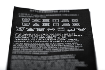 Fototapeta premium Macro photography of clothing label with instructions, expressed by means of graphic symbols on how to clean