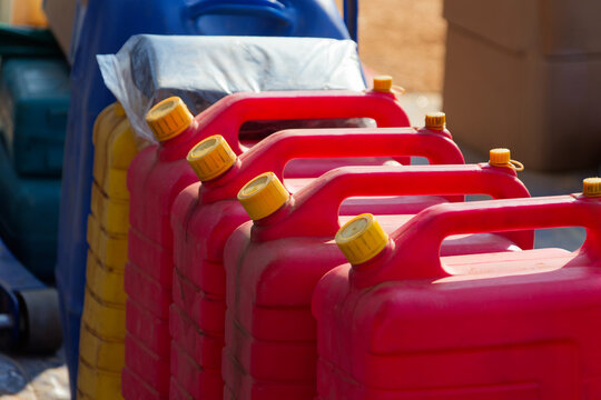 Row of Red Plastic Fuel Jerry Cans for Emergency Resource Storage energy crisis or fuel shortage