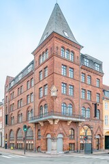Fototapeta premium Historic Red Brick Corner Building Architecture in Copenhagen, Denmark, Danish Facade