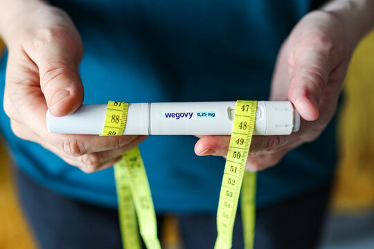 Wroclaw, Poland. January 5, 2026. Close-up of hands holding Wegovy weight loss injection pen with measuring tape, illustrating modern obesity treatment and weight management concept.