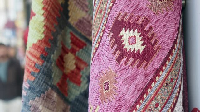 Two traditional turkish rugs hanging side by side, showcasing their intricate patterns and vibrant colors, captured with a shallow depth of field, blurred background
