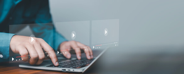 Close up of hands using laptop with virtual video player interface overlay, representing streaming media technology, online learning, content creation, digital marketing, and multimedia entertainment © ภัทรชัย รัตนชัยวงค์