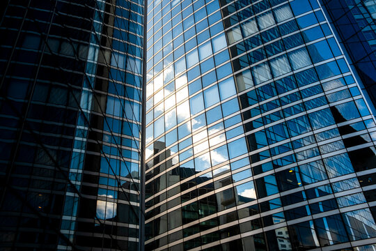 Sunlight reflection on glass windows of modern office skyscraper architecture facade rising in strong perspective for contemporary corporate background