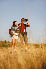 Couple of environmental scientists doing field research in nature watchin and listing birds
