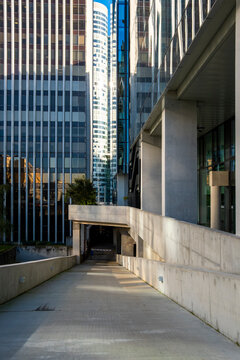 Minimal modern office corridor in La Defense Paris France with symmetry hard shadows and clean architectural lines creating an empty urban passage in daylight
