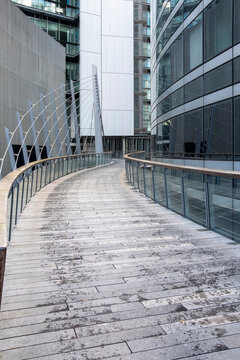Empty pedestrian walkway with strong leading lines in La Defense Paris France framed by modern offices creating deep perspective in a financial district corridor