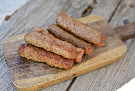 Grilled  meal on barbeque. on  wooden Background.  Small sausages from minced meat, a very popular dish in the Balkan countries. 