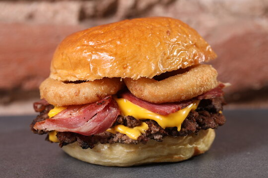 Un cheeseburger avec oignons frits et viande