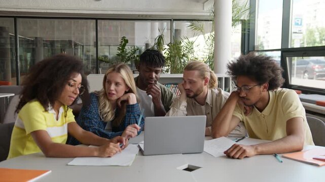 Diversity five students with laptop studying boring online learning boredom sleepy tired study at table in university college multiracial friends e-learning preparing for exams difficulty problem