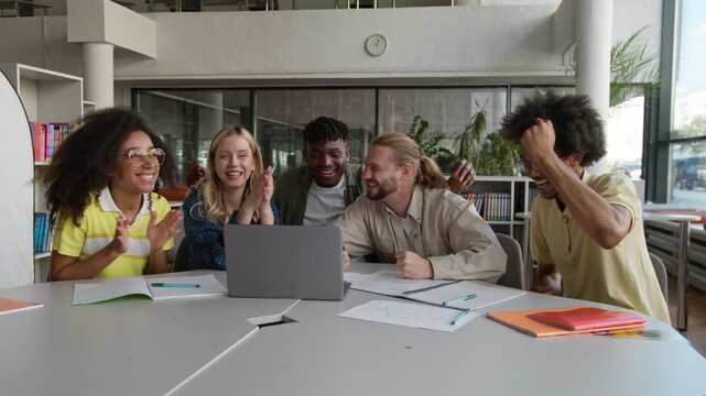 Group of successful five happy multiethnic students celebrate online success with laptop studying learning teamwork diversity friends winning with computer cheering achieve passed exams in university