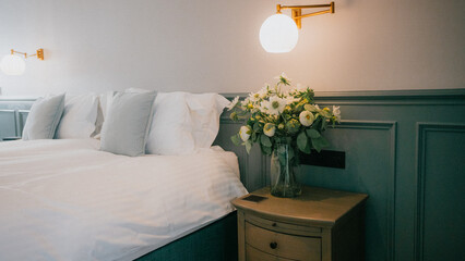 Cozy bedroom with soft lighting and fresh flowers © Reuben