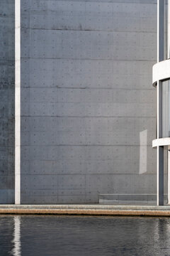 Minimal modern architecture concrete wall with water reflection showing abstract geometry and texture creating a calm background with clean lines
