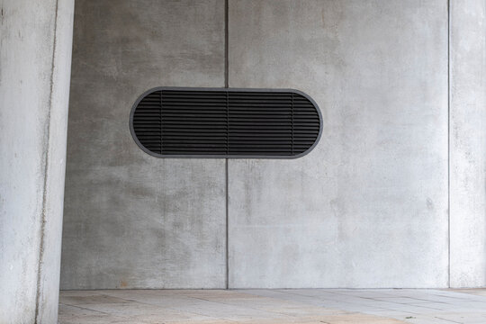 Modern minimal architecture concrete wall with vent grille and centered symmetry showing abstract texture and clean lines for contemporary background