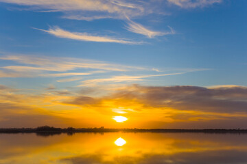 Obraz premium dramatic sunset on blue sky over the calm wide lake