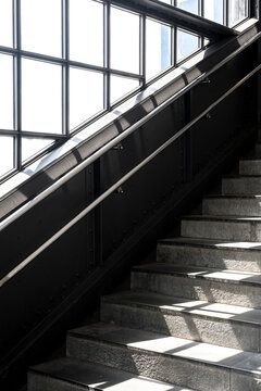 Interior stairs near window where light and shadow form modern geometry in abstract space suggesting up movement and progress in minimal architecture