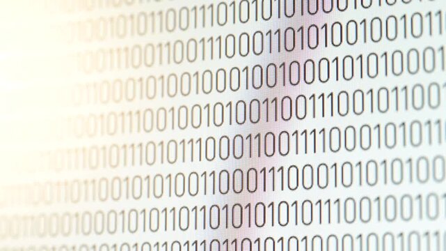 Digital binary code of ones and zeros flowing upwards on the monitor screen. Binary data stream of zeros and ones moving up the screen, symbolizing information processing and computing