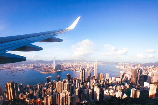 Airplane Wing Flying Over Hong Kong Skyline and Victoria Harbour