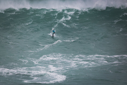 surfeando en las olas de Nazare en Portugal
