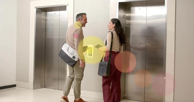 Office duo walking to lift, woman pressing call button, bubbles growing as sharing tablet for work