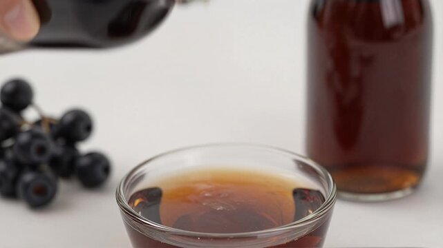 Refreshing Dark Beverage in Glass with Blueberries and Bottle