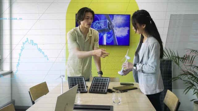 Man explaining energy prototype urging woman picking turbine and aligning solar with tablet graphic