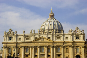 St. Peter's Basilica in Vatican City, Rome, Italy, with its iconic dome and facade adorned with statues and a clock. © Nick