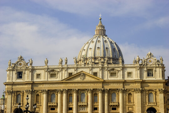 St. Peter's Basilica in Vatican City, Rome, Italy, with its iconic dome and facade adorned with statues and a clock.