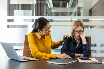 Colleague showing empathy and support for stressed businesswoman