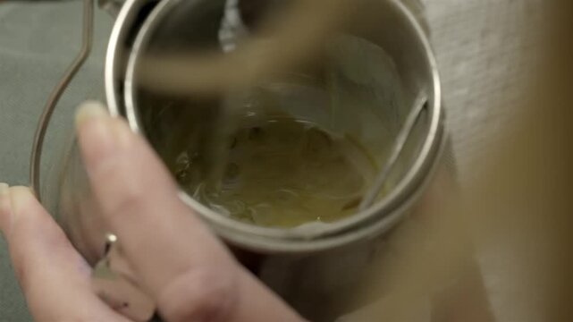 Professional artist mixing paint solvent in metal canister close up