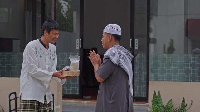 Muslim man hands giving rice zakat to neighbor at mosque practicing Zakat Al-Fitr charity