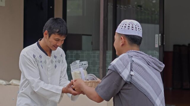 Smiling Muslim man receives basket of rice and food as Zakat donation during Ramadan