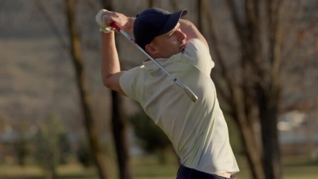 Tight shot of a professional golfer performing a powerful swing in Sion, Switzerland. Focused motion, precision technique, and cinematic sports action on an alpine golf course.
