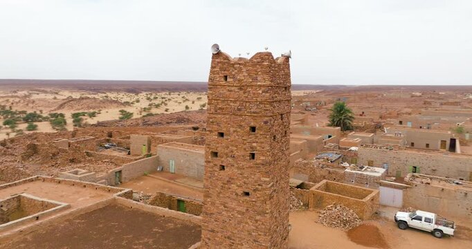 Brick Stone Minaret Of The Historic Mosque In The Ancient Caravan Town Of Ouadane, Mauritania. Aerial Rotate Shot