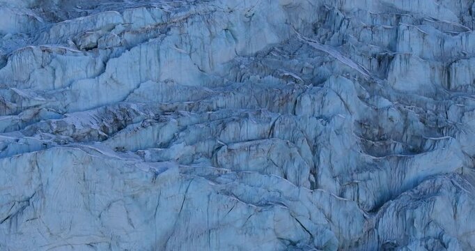 Aerial drone shot showing a vast snow-covered glacier landscape near Lobuche surrounded by rugged Himalayan terrain in the Everest region of Nepal.