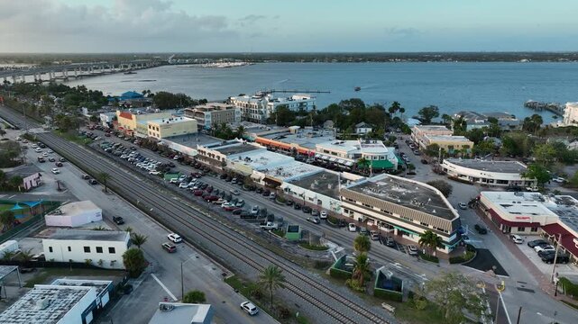 A sweeping drone view reveals the small-town charm of downtown Stuart surrounded by tropical greenery and waterfront scenery.