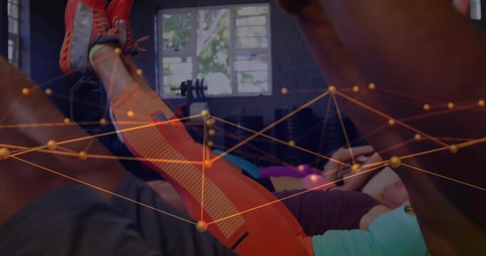 Coach cueing fitness class, group doing V-up core reps on mats, overlay linking nodes across frame