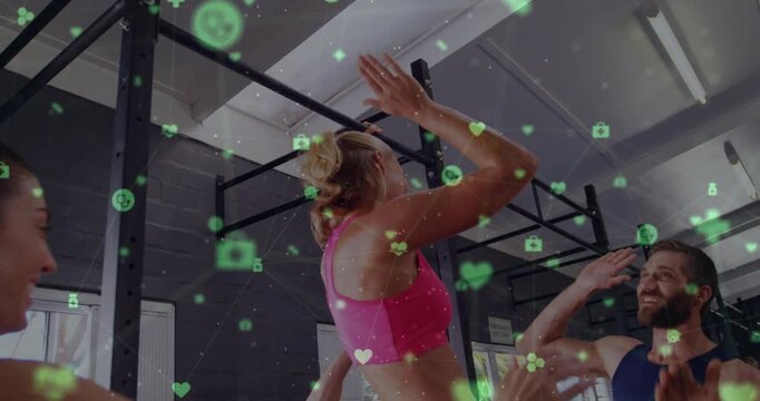 Woman reaching pullup top highfiving coach celebrating fitness win as green icons rising around bar