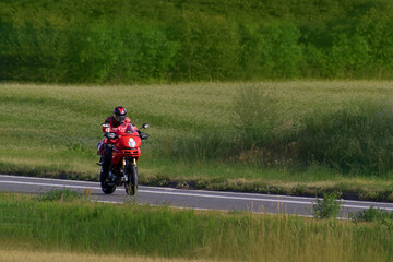 Obraz premium Motorcycle rider moving along a scenic rural road path