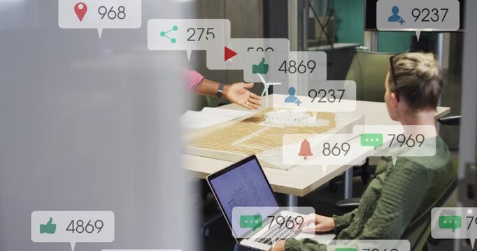 Sr male lead pointing at turbine model, woman typing alerts appearing over table driving marketing