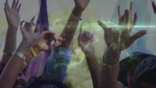 Festival attendees raising hands and making horn signs at music cue, green nebula sweeping across
